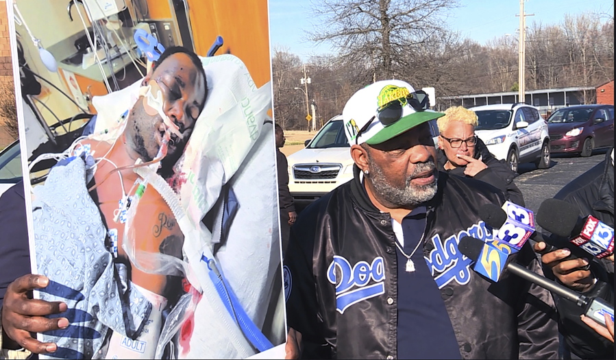 In this photo provided by WREG, Tyre Nichols' stepfather Rodney Wells, right, holds a photo of Nichols in the hospital after his arrest, during a protest in Memphis, Tenn., Saturday, Jan. 14, 2023.