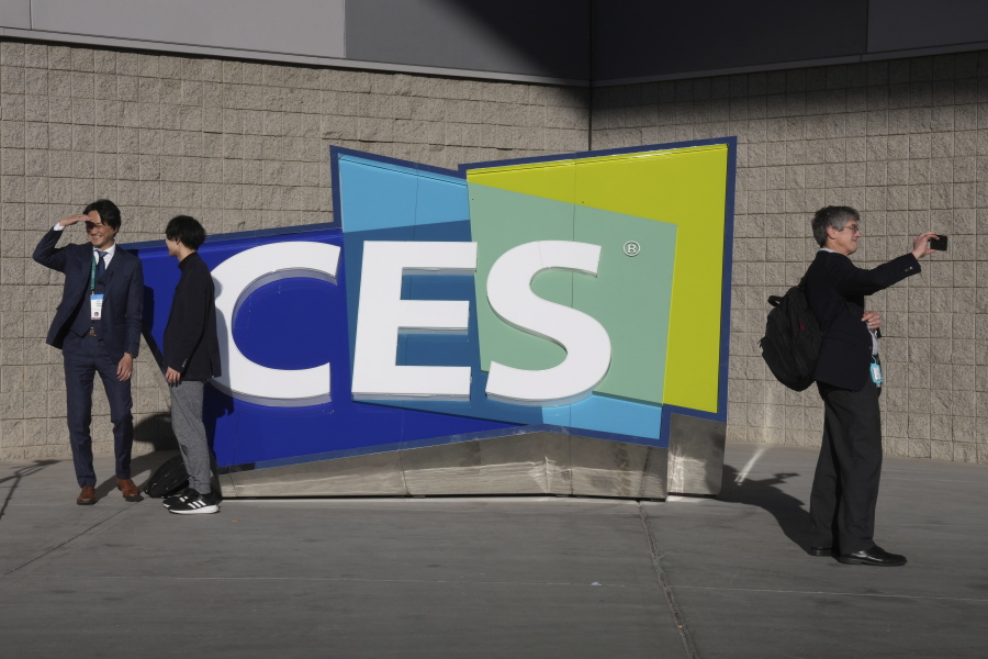 FILE - People take pictures in front of a sign during the CES tech show on Jan. 6, 2022, in Las Vegas. CES is returning to Las Vegas in January 2023 with the hope that it inches closer to how it looked before the pandemic.