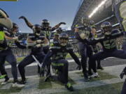 The Seattle Seahawks celebrate after an interception by safety Quandre Diggs during overtime against the Los Angeles Rams Sunday in Seattle.
