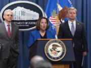 Deputy Attorney General Lisa Monaco flanked by Attorney General Merrick Garland, left, and Federal Bureau of Investigation (FBI) Director Christopher Wray speaks during a news conference to announce an international ransomware enforcement action, at the Department of Justice in Washington, Thursday, Jan. 26, 2023. The FBI has seized the website of a prolific ransomware gang that has heavily targeted hospitals and other healthcare providers.