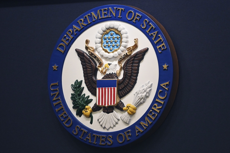 FILE - The State Department seal is seen on the briefing room lectern at the State Department in Washington, Jan. 31, 2022. Everyday Americans will be able to help refugees adjust to life in the U.S. in a program being launched by the State Department. The goal is to give private citizens a role in resettling the thousands of refugees who come to America every year.