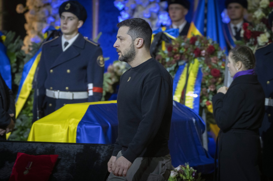 Ukrainian President Volodymyr Zelenskyy pays his respects to victims of a deadly helicopter crash during a farewell ceremony in Kyiv, Ukraine, Saturday, Jan. 21, 2023. Interior Minister Denys Monastyrsky, his Deputy Yevhen Yenin, State Secretary Yurii Lubkovych, national police official and the three crew members were killed in a helicopter crash on Wednesday in Kyiv suburbs of Brovary.