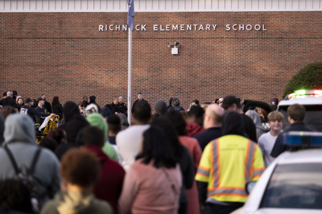 Students and police gather outside of Richneck Elementary School after a shooting, Friday, Jan. 6, 2023 in Newport News, Va. A shooting at a Virginia elementary school sent a teacher to the hospital and ended with "an individual" in custody Friday, police and school officials in the city of Newport News said.