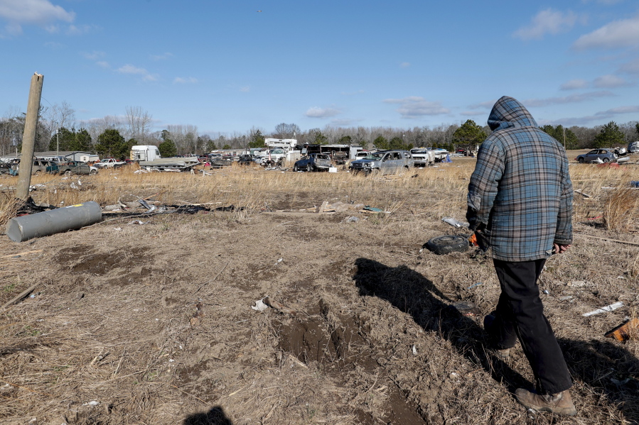 David Hollon walks his property looking for personal items as they recover from a tornado that ripped through Central Alabama earlier this week along County Road 140 where loss of life occurred Saturday, Jan. 14, 2023, in White City, Autauga County, Ala.
