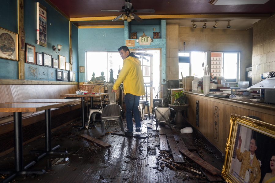 Dominic King, owner of My Thai Beach, surveys storm damage that destroyed his restaurant in Capitola, Calif., Thursday, Jan. 5, 2023. Damaging hurricane-force winds, surging surf and heavy rains from a powerful "atmospheric river" pounded California on Thursday, knocking out power to tens of thousands, causing flooding, and contributing to the deaths of at least two people, including a child whose home was hit by a falling tree.