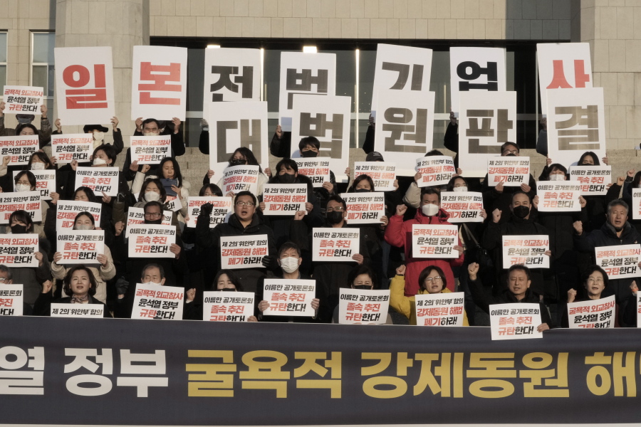 Members of a civic group seeking compensation from Japanese firms over forced labor during World War II and opposition lawmakers stage a rally to oppose the government's reported resolution to the issue outside the National Assembly in Seoul, Thursday, Jan. 12, 2023.