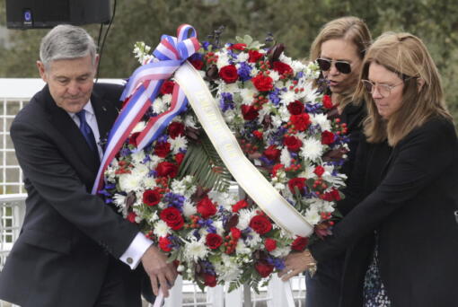 A wreath is presented by, from left, Bob Cabana, Associate Administrator of NASA; Janet Petro, NASA KSC director, and Sheryl Chaffee, daughter of Apollo 1 astronaut Roger Chaffee, during NASA's Day of Remembrance ceremony, hosted by the Astronauts Memorial Foundation at Kennedy Space Center Visitor Complex, Thursday, Jan. 26, 2023. NASA is marking the 20th anniversary of the space shuttle Columbia tragedy with somber ceremonies during its annual tribute to fallen astronauts. (Joe Burbank/Orlando Sentinel via AP)