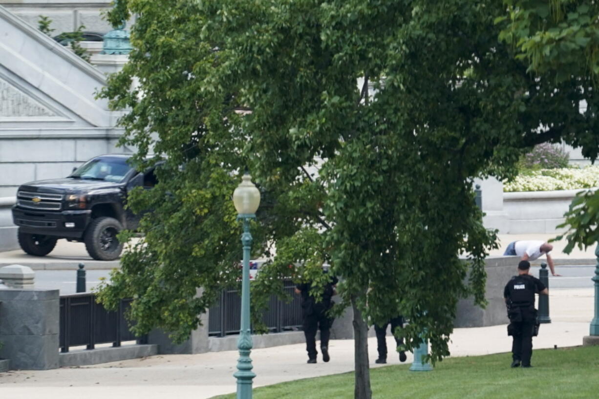 FILE - A man is apprehended after being in a pickup truck parked on the sidewalk in front of the Library of Congress' Thomas Jefferson Building, as seen from a window of the U.S. Capitol, Aug. 19, 2021, in Washington. A man who caused evacuations and an hourslong standoff with police on Capitol Hill when he claimed he had a bomb in his pickup truck outside the Library of Congress pleaded guilty on Friday, Jan. 27, 2023, to a charge of threatening to use an explosive. Floyd Ray Roseberry faces up to 10 years behind bars and is scheduled to be sentenced in June.