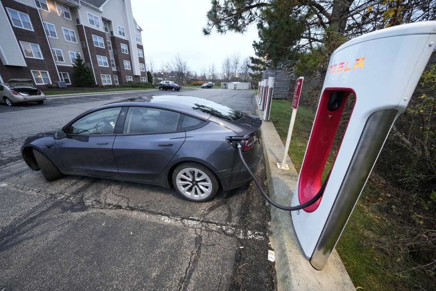 FILE - A Tesla sedan gets a charge at a Tesla Supercharging station in Cranberry, Pa, Wednesday, Nov. 16, 2022. With its sales slowing and its stock price tumbling, Tesla Inc. slashed prices dramatically Friday on several versions of its electric vehicles, making some of its models eligible for a new federal tax credit that could help spur buyer interest. (AP Photo/Gene J.