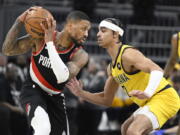 Portland Trail Blazers guard Damian Lillard, left, keeps the ball away from Indiana Pacers guard Andrew Nembhard (2) during the second quarter of an NBA basketball game, Friday, Jan. 6, 2023, in Indianapolis.