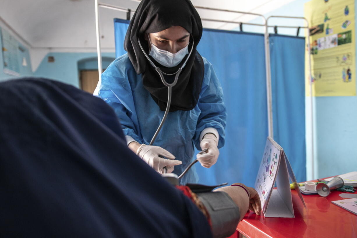 FILE - A Save the Children midwife provides Zarmina, 25, who is five months pregnant, with a pre-natal check-up in Jawzjan province in northern Afghanistan, Sunday, Oct. 2, 2022.
