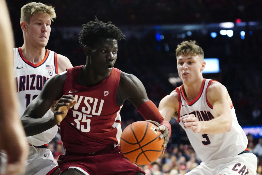 Washington State's Mouhamed Gueye (35) looks to get out of a double-team by Arizona's Azuolas Tubelis, left, and Pelle Larsson, right, during the first half of an NCAA college basketball game, Saturday, Jan. 7, 2023, in Tucson, Ariz.