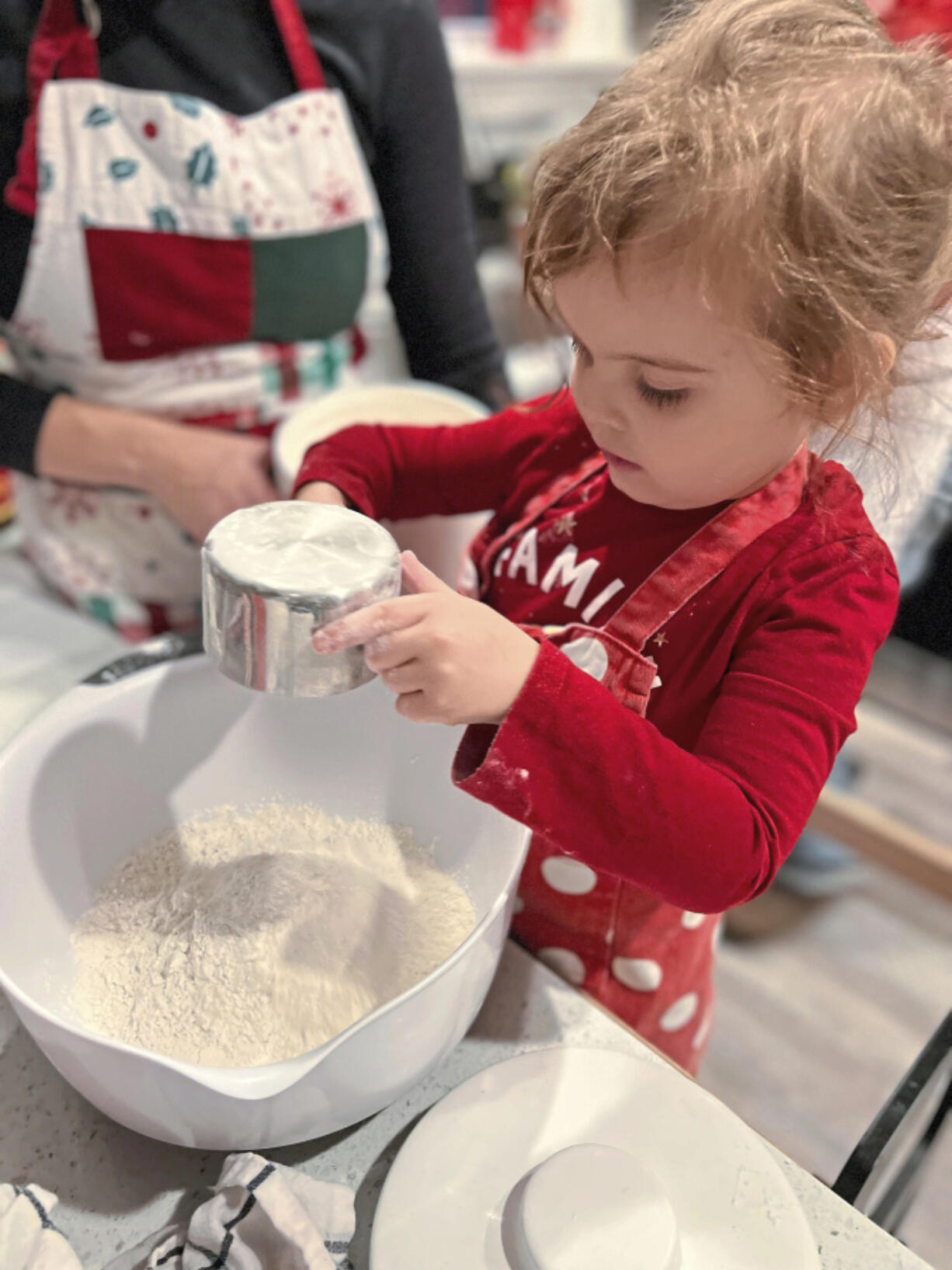 Lindsay Gardner and her 3-year-old daughter,  Ellie, measure flour into a mixing bowl for cookies.