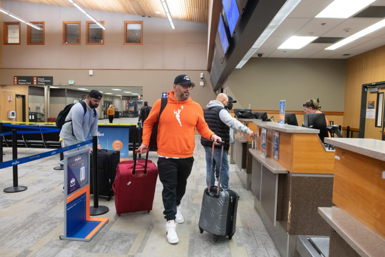 Karn and Arun Dodd of Victoria, B.C., wheel their bags to the Allegiant checkout counter at Bellingham International Airport on Jan. 27. Proximity to the border and low fares make the airport particularly attractive to Canadians hoping to fly into the United States.