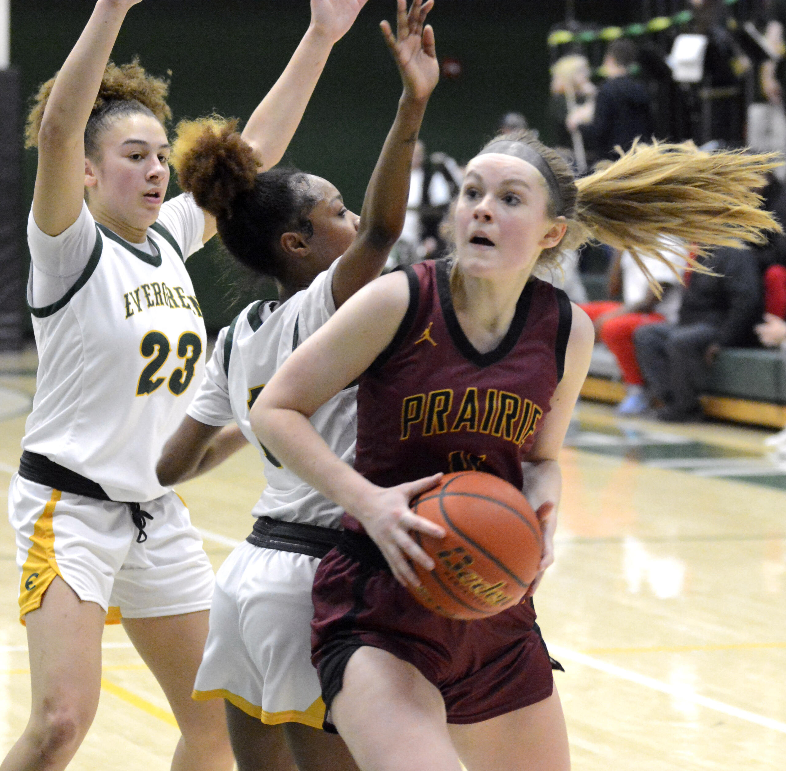 Prairie’s Claire Smith, right, spins past Evergreen defenders Adrian Wright, left, and Lavalerie Lindsey on Wednesday, Feb. 1, 2023, at Evergreen High School.