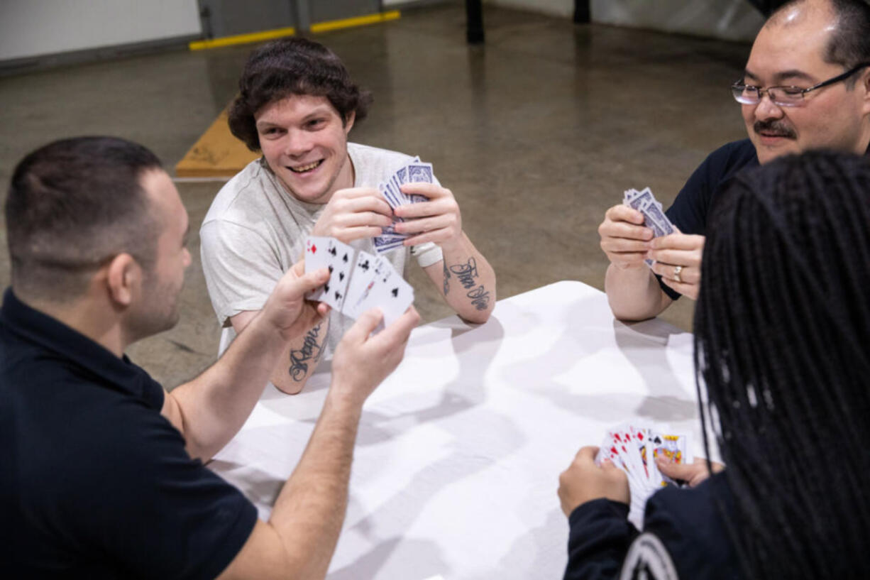 Shawn Crump, 31, plays cards with correctional officers from Stafford Creek Corrections Center on Wednesday, Jan. 18, 2023 in Aberdeen. In the Amend program, incarcerated individuals are able to take an hour or two to play games, talk or learn about ways to apply themselves when they???re released.