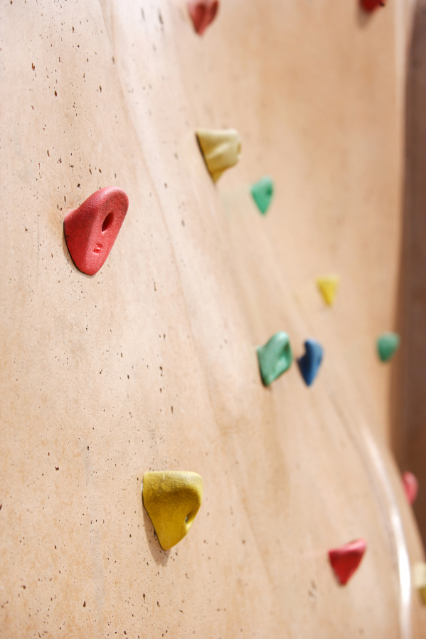 A rock climbing wall in a play area.