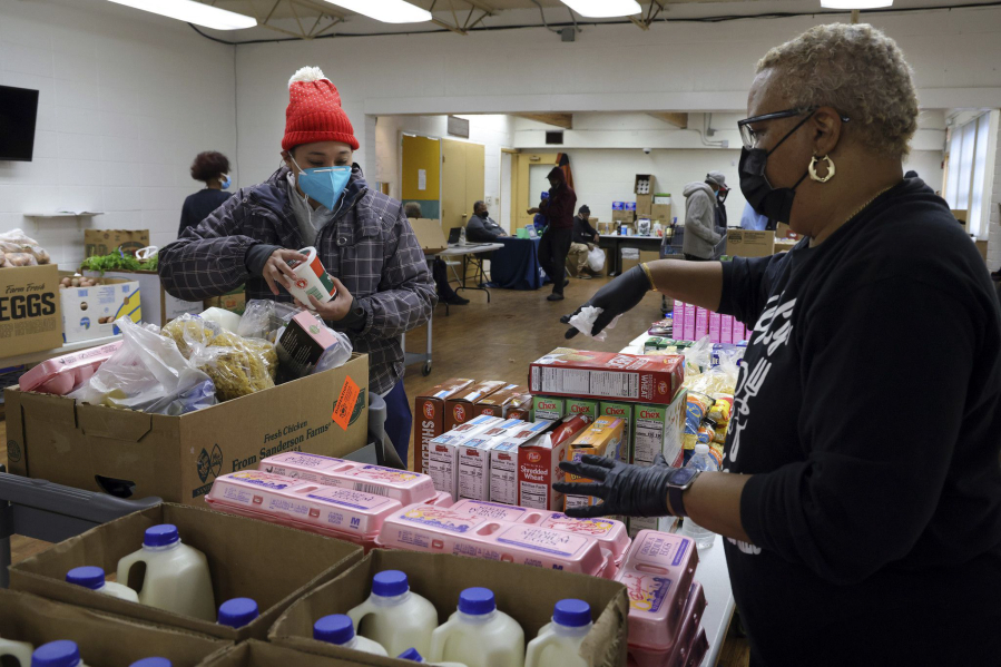 At Chosen Tabernacle Ministries pantry in Chicago, Johanna Lezama, left, chooses food with the help of Angela Bailey-Lane on Feb.