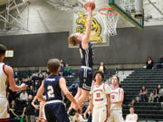 Seattle Christian players look on as Seton Catholic's Jack Jenniges elevates for a two-handed dunk during a Class 1A state opening round game on Friday, Feb. 24, 2023, at Auburn High School.