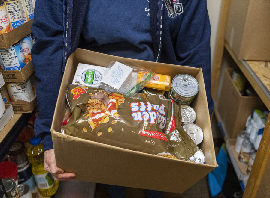 Clark County Veterans Assistance Center Vice President Ruth Lakel holds a box of food at the center. The organization operates a food pantry that gives out boxes to individuals and families.