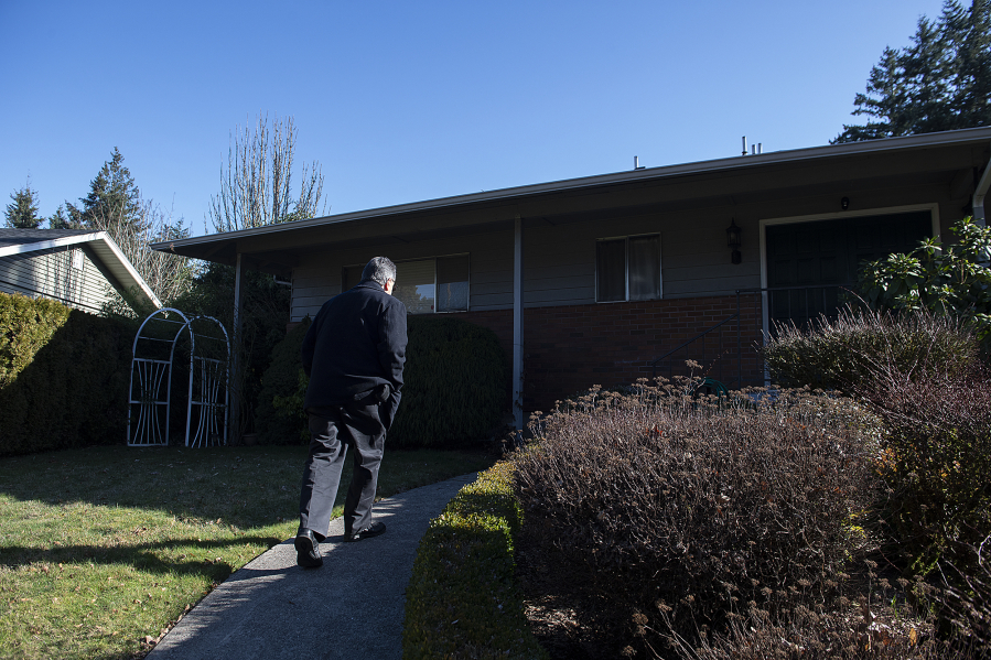 Volunteer Bruce Eavey of Villages Clark County walks to the front door of Hazel Dell resident Frankie Shetterly as he picks her up for an appointment on a recent morning.