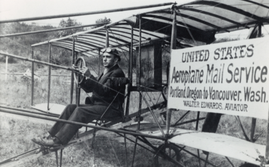 A former banker turned daredevil pilot, Walter Edwards Kittel, sits in the airplane Silas Christofferson flew off a Portland hotel. He flew as Walter Edwards throughout the Pacific Northwest. In 1912, he carried the first batch of airmail between Portland and Vancouver in this airplane making the first interstate airmail delivery in the United States.