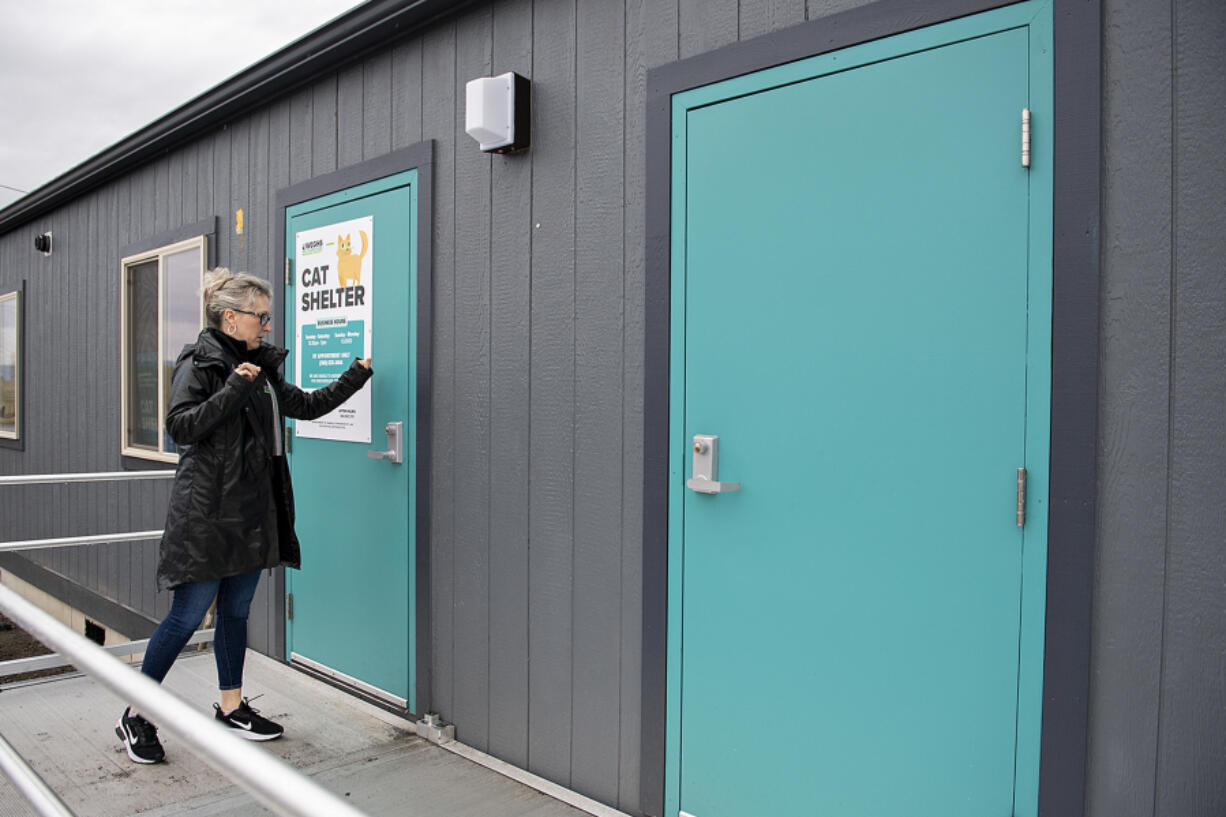 Micki Simeone of the West Columbia Gorge Humane Society cat building knocks on the front door before entering the new facility. The building, a former portable classroom, replaces an old mobile home with a collapsing roof.