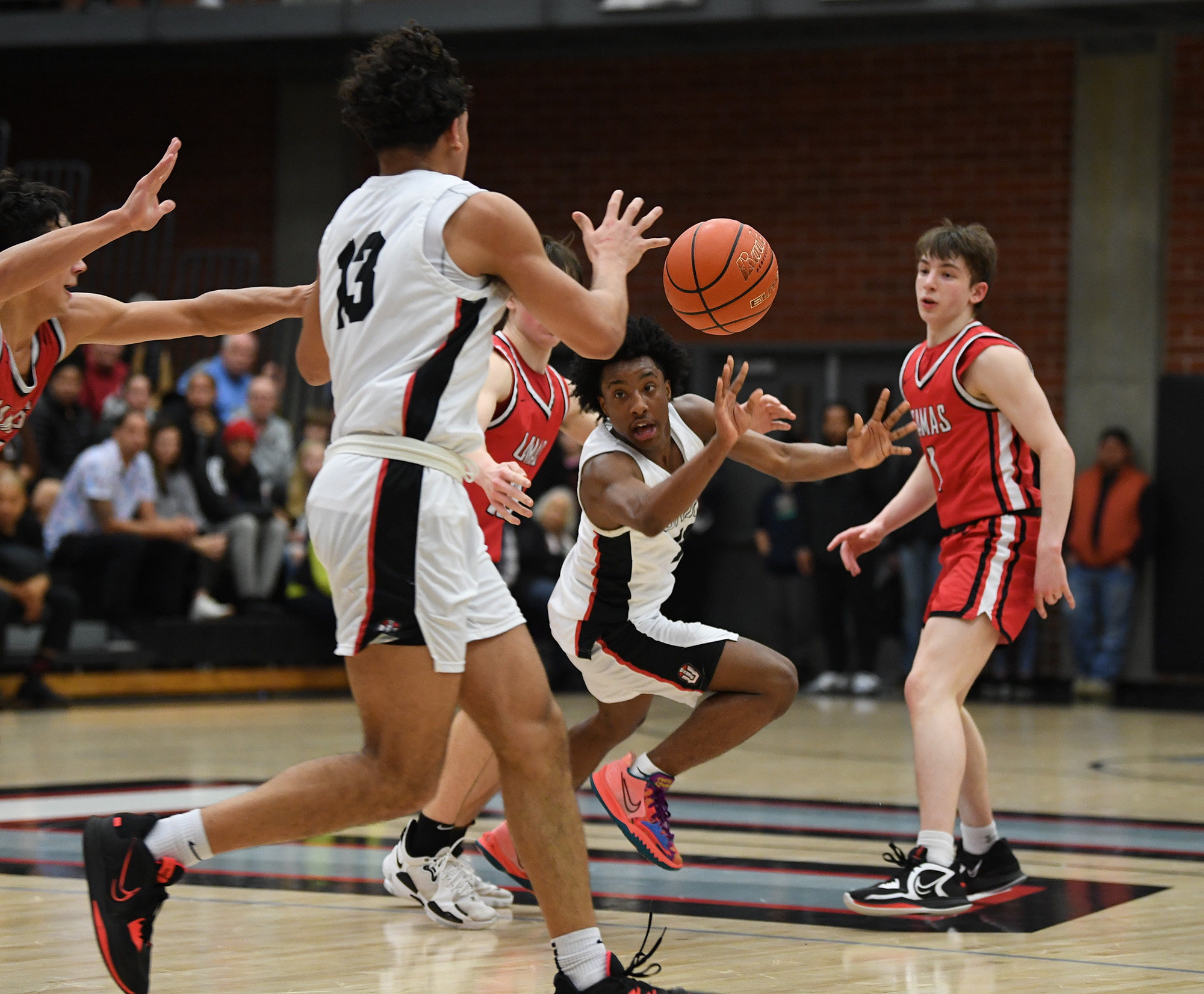 Union junior Nolan Frazier, center, passes the ball to Union senior Yanni Fassilis on Friday, Feb. 3, 2023, during the Titans’ 76-65 win against Camas at Union High School.
