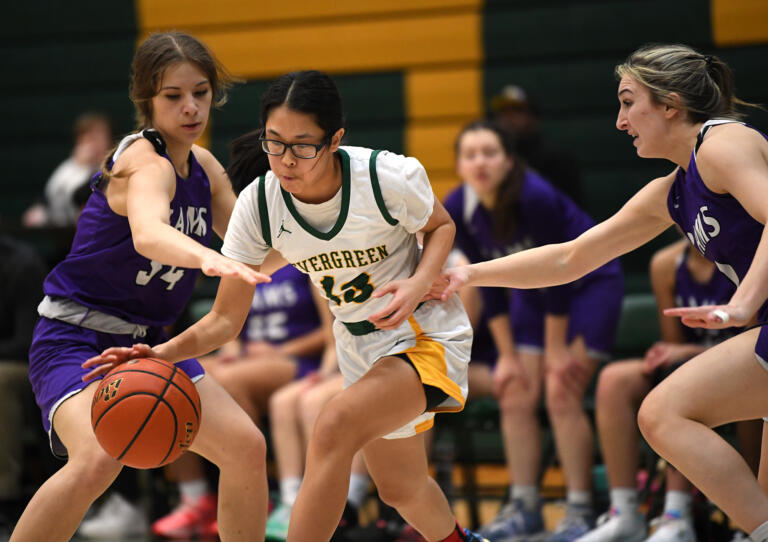 Evergreen junior Christina Nguyen, center, dribbles between defenders Friday, Feb. 10, 2023, during the Plainsmen’s 78-38 loss to North Thurston at Evergreen High School.