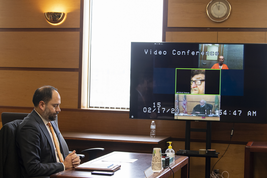 Defense attorney Sean Downs, left, listens as his client, serial killer Warren Forrest, top to bottom on screen, appears on video conference with Michael Morrison, brother of victim Martha Morrison, and Judge Robert Lewis in Clark County Superior Court on Friday afternoon. Michael Morrison gave a statement at the sentencing of Forrest for the murder of his sister.
