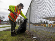 Outpost resident Courtney Ligman, who works in Share's Talkin' Trash program, picks up garbage across from Fort Vancouver High School on a Tuesday afternoon in February.