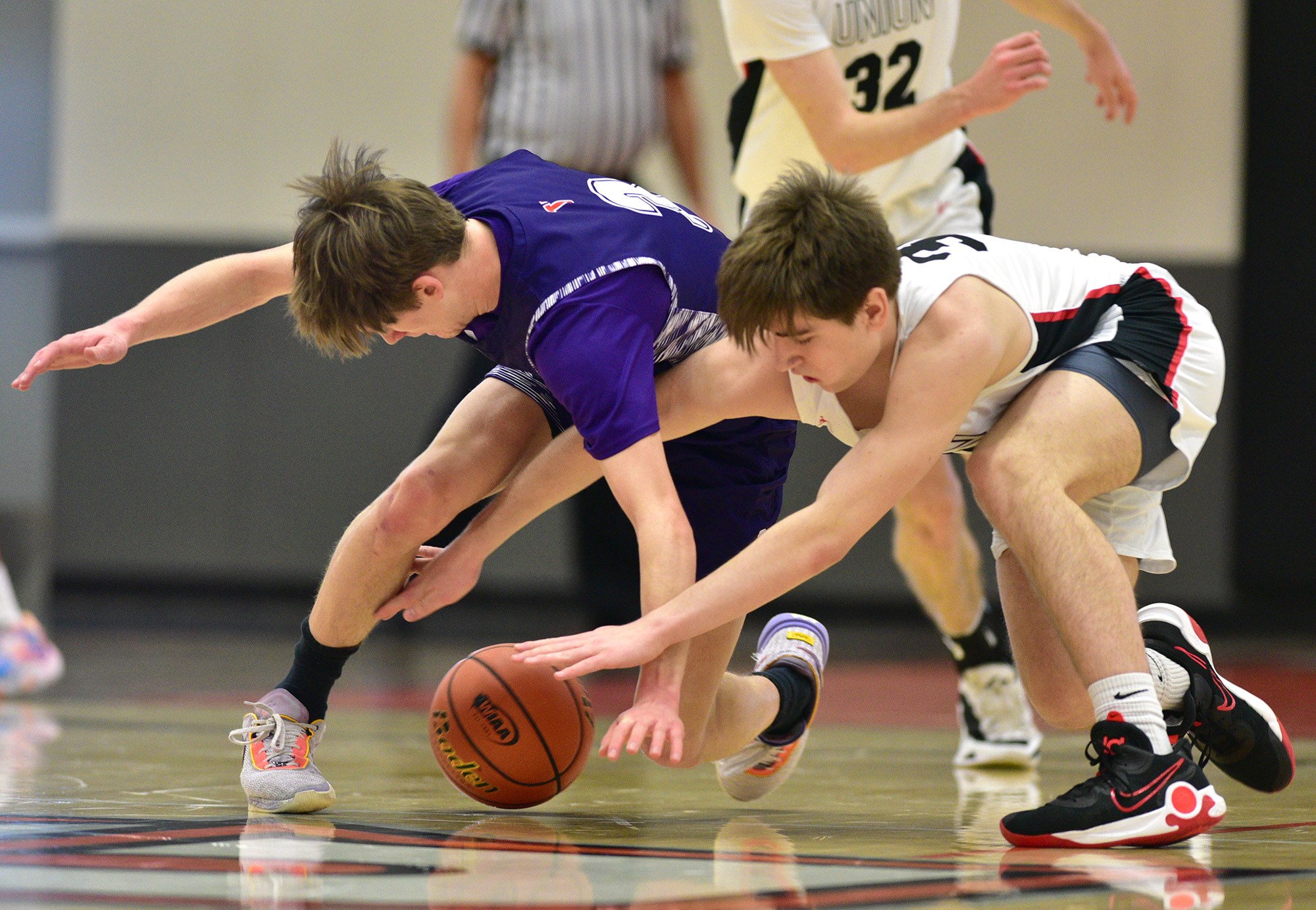 Union junior Tucker Dunseth, right, and Sumner senior Kaden Kastberg fight for a loose ball Saturday, Feb. 25, 2023, during the Titans’ 67-40 at Battle Ground High School.