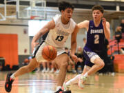 Union senior Yanni Fassilis, center, dribbles the ball under pressure from Sumner junior Luke Bohl on Saturday, Feb. 25, 2023, during the Titans’ 67-40 at Battle Ground High School.