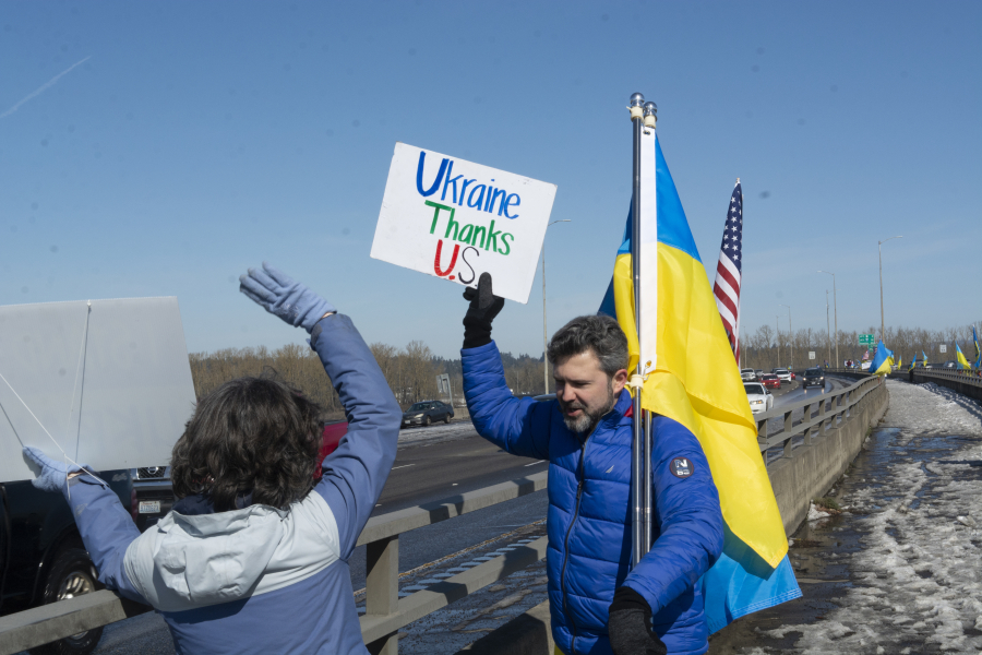 Vancouver resident Andrey Shulik, right, and Maria Everhart stand on the Interstate 205 bridge pedestrian path on Saturday afternoon during a weekly rally raising awareness of the war in Ukraine. Saturday marked the 51st weekend that the rally has taken place.