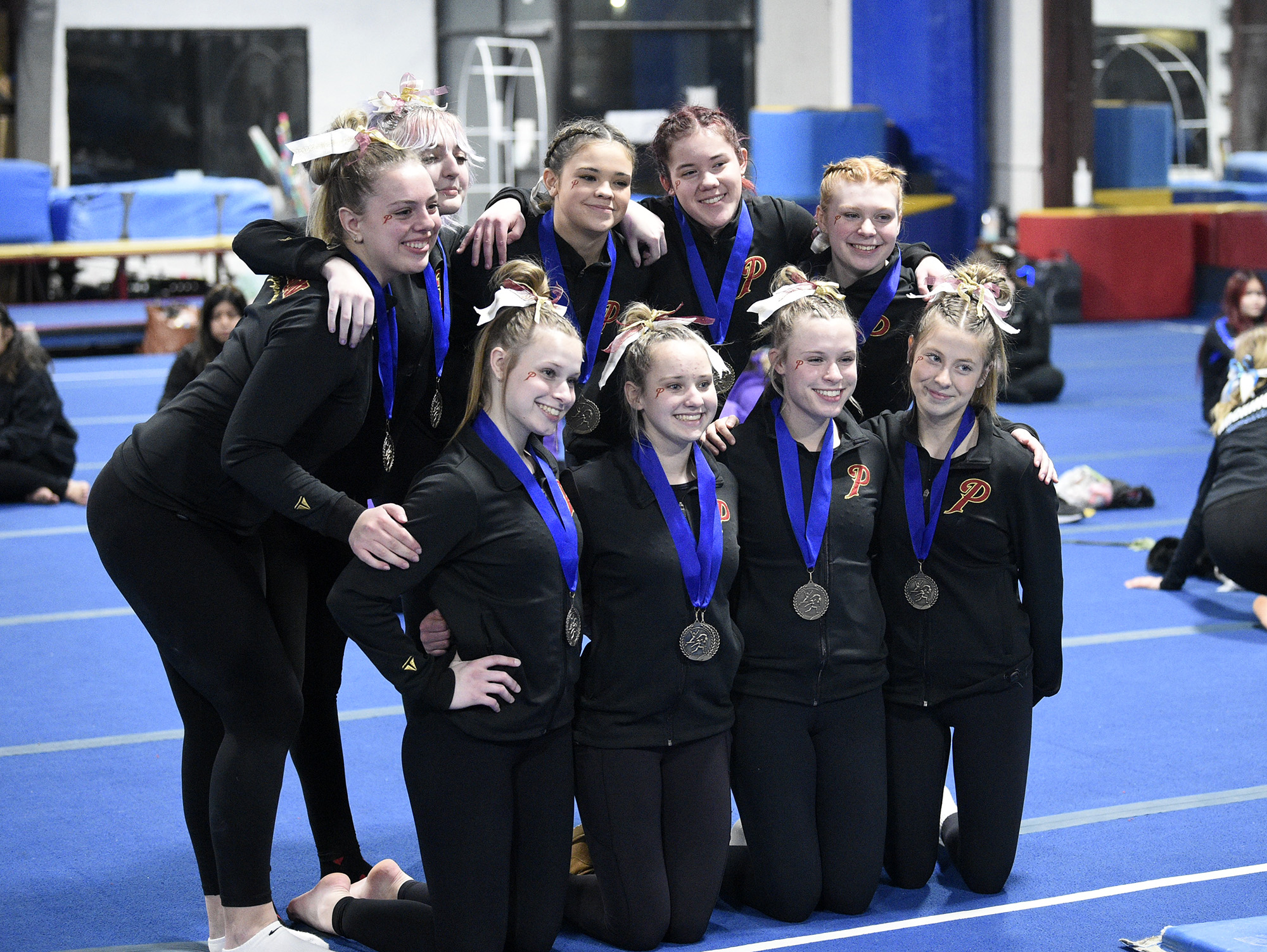 The Prairie gymnastics team poses for a photo after capturing the team title at the Class 3A District 4 meet at Northpointe on Saturday, Feb. 11, 2023.