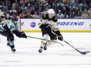 Boston Bruins left wing Jake DeBrusk (74) skates with the puck as Seattle Kraken right wing Oliver Bjorkstrand (22) defends during the third period of an NHL hockey game Thursday, Feb. 23, 2023, in Seattle. The Bruins won 6-5.