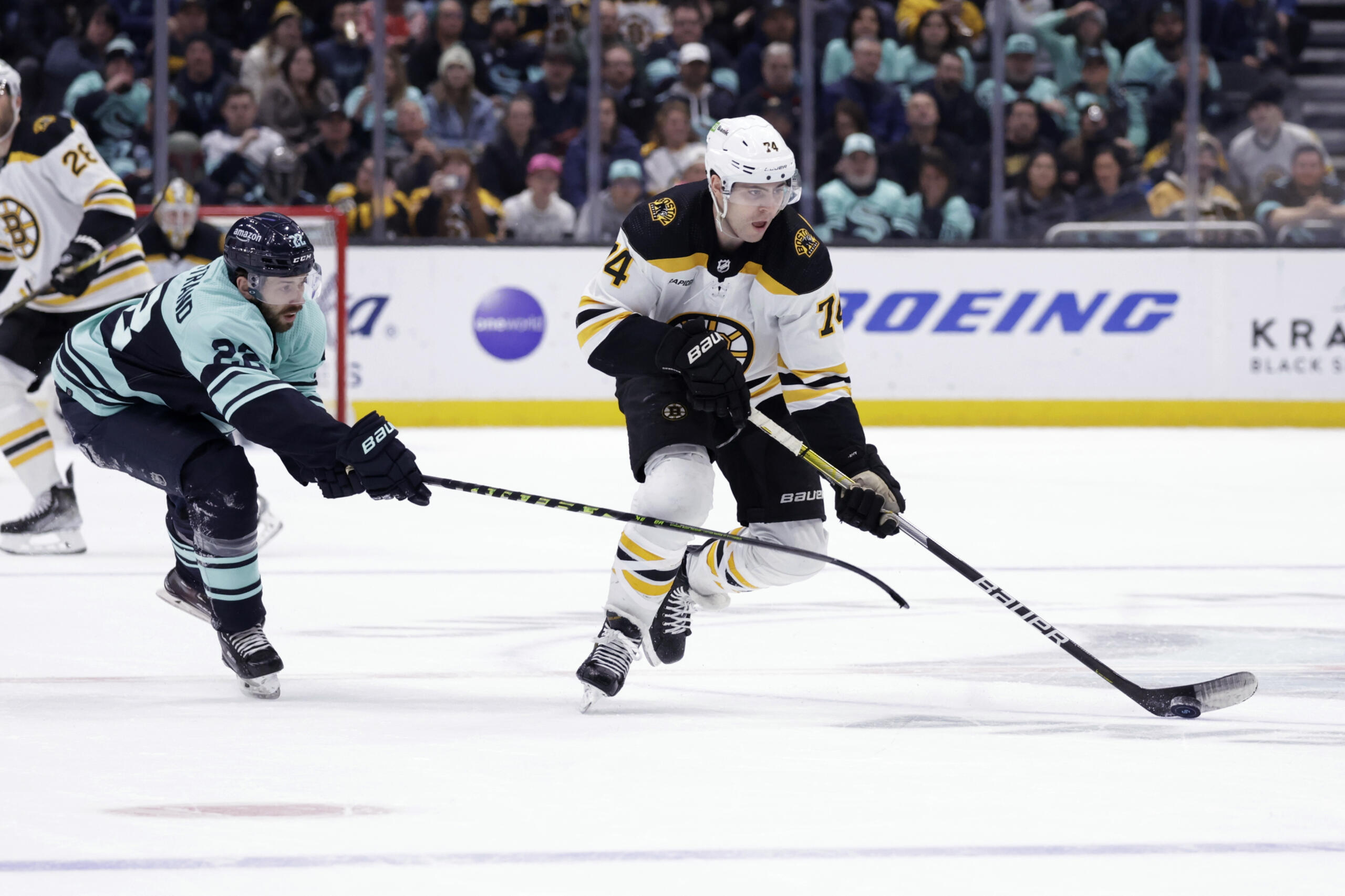Boston Bruins left wing Jake DeBrusk (74) skates with the puck as Seattle Kraken right wing Oliver Bjorkstrand (22) defends during the third period of an NHL hockey game Thursday, Feb. 23, 2023, in Seattle. The Bruins won 6-5.