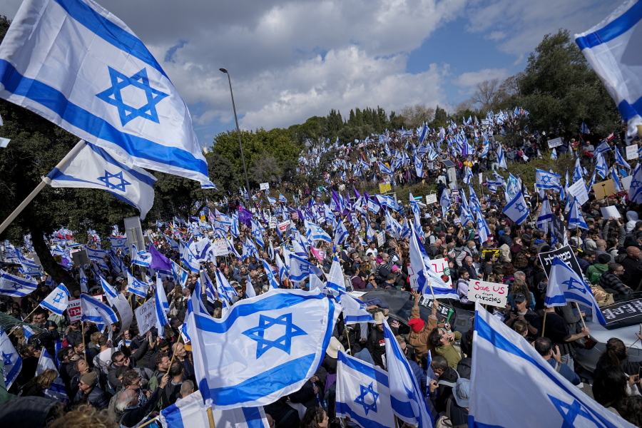 Israelis wave national flags during protest against plans by Prime Minister Benjamin Netanyahu's new government to overhaul the judicial system, outside the Knesset, Israel's parliament, in Jerusalem, Monday, Feb. 13, 2023. Thousands of Israelis protested outside the country's parliament on Monday ahead of a preliminary vote on a bill that would give politicians greater power over appointing judges, part of a judicial overhaul proposed by Prime Minister Benjamin Netanyahu's government.