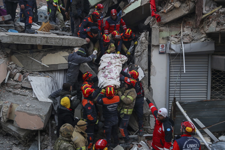 Turkish rescue workers carry Ergin Guzeloglan, 36, to an ambulance after pulled him out from a collapsed building five days after an earthquake in Hatay, southern Turkey, early Saturday, Feb. 11, 2023. Emergency crews made a series of dramatic rescues in Turkey on Friday, pulling several people, some almost unscathed, from the rubble, four days after a catastrophic earthquake.