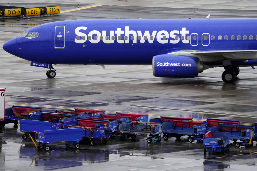 A Southwest Airlines jet passes unused luggage carts as it arrives, Dec. 28, 2022, at Sky Harbor International Airport in Phoenix. Congress is hearing today about the December meltdown at Southwest Airlines. A Southwest executive said in prepared testimony Thursday, Feb. 9, 2023 that the airline is taking steps to avoid a repeat of the breakdown that led to nearly 17,000 canceled flights over the December holidays.