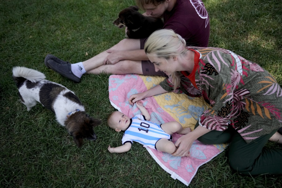 Russian nationals Alla Prigolovkina and her husband Andrei Ushakov, their Argentine-born son Lev Andres and their dogs Santa and Cometa, visit a park in Mendoza, Argentina, Tuesday, Feb. 14, 2023. In spite of the language barrier and the stifling summer heat, Prigolovkina and Ushakov have quickly adopted Argentine customs since their July move. Prigolovkina said they especially enjoy spending time in the park with their dogs.