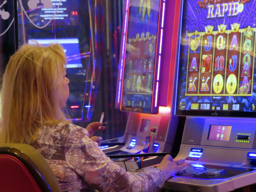 A gambler smokes while playing a slot machine at the Hard Rock casino in Atlantic City N.J. on Aug. 8, 2022. On Monday Feb. 13, 2023, lawmakers will hold their first hearing on a bill that would ban smoking in Atlantic City's nine casinos.