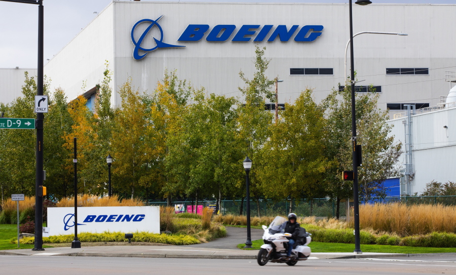 FILE - A motorcyclist cruises past the Renton, Wash., Boeing plant where 737's are built on Oct. 28, 2020. Boeing plans to make staffing cuts in the aerospace company's finance and human resources support services departments in 2023, with a loss of around 2,000 jobs, the company said Monday, Feb. 6, 2023.  (Ellen M.