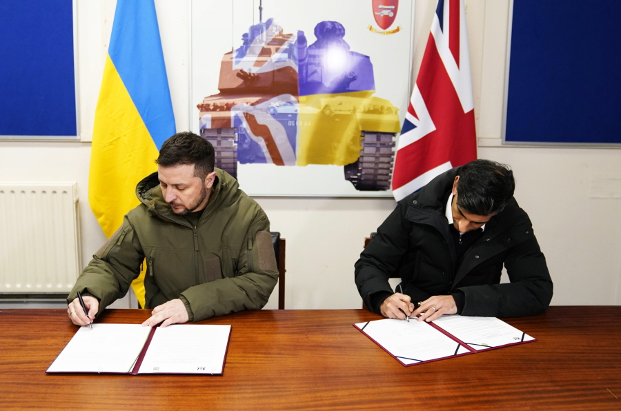 Ukrainian President Volodymyr Zelensky, left, and British Prime Minister Rishi Sunak sign a declaration of unity at a military facility in Lulworth, Dorset, England, Wednesday Feb. 8, 2023.