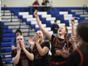 Camas' Kendall Bachelder (10), Marta Biasiolo (22) and Addison Harris cheer as assistant coach Lisa Schneider cuts the net after the Papermakers' win in the 4A bi-district girls basketball championship game at Curtis High School in University Place on Saturday, Feb. 18, 2023.