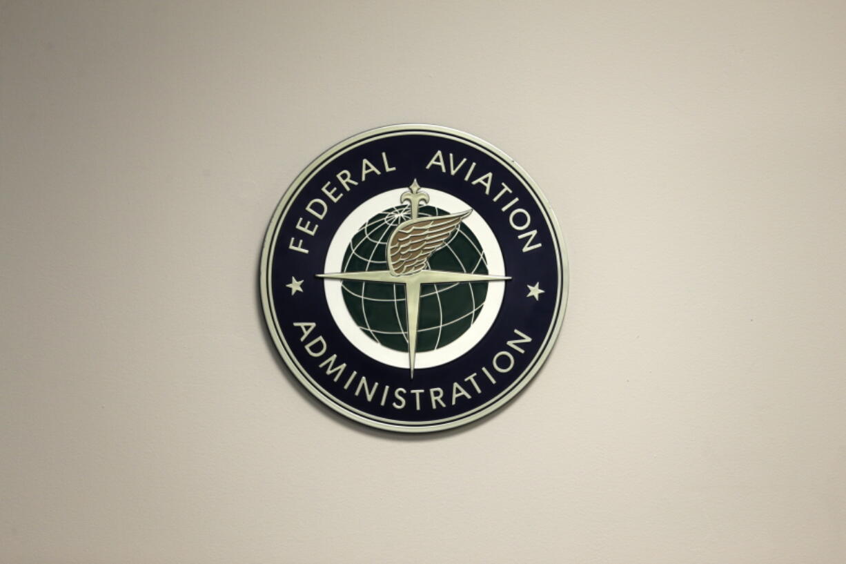 FILE - A Federal Aviation Administration sign hangs in the tower at John F. Kennedy International Airport in New York, March 16, 2017.  Congress is taking up key aviation legislation just after close calls between planes at airports in New York and Texas. A House committee held the first hearing Tuesday, Feb. 7, 2023,  on legislation that will govern the Federal Aviation Administration.