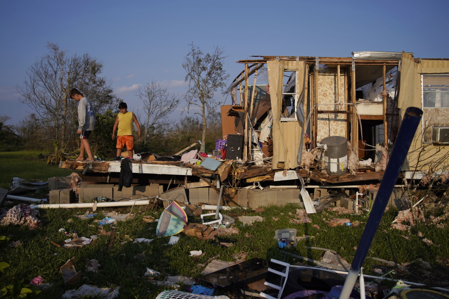 FILE - Aiden Locobon, left, and Rogelio Paredes look through the remnants of their family's home destroyed by Hurricane Ida, Sept. 4, 2021, in Dulac, La. A new study says that back-to-back hurricanes that hit the same general place in the United States seem to be happening more often.