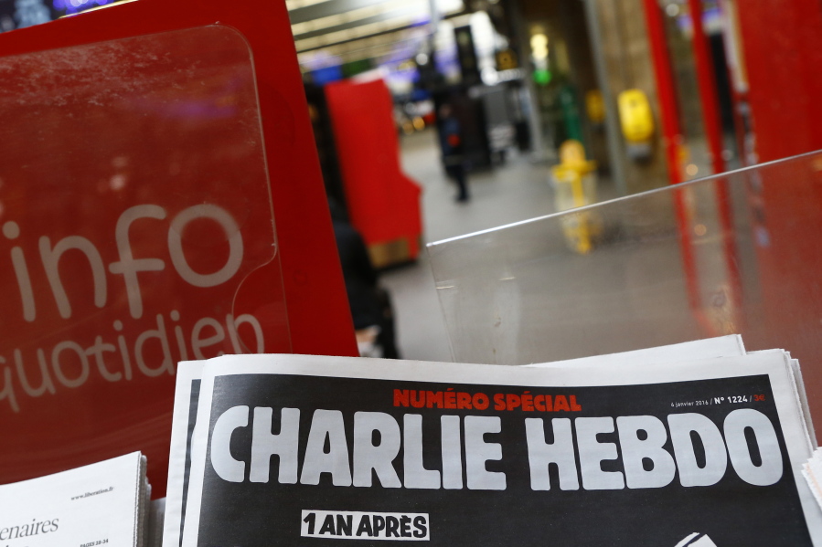 FILE - A special edition of the satirical newspaper Charlie Hebdo that marks one year after, "1 an apres" the attacks on it, on a newsstand Wednesday, Jan. 6, 2016 at a train station in Paris. After the French satirical magazine Charlie Hebdo's launched a cartoon contest to mock Iran's ruling cleric, a state-backed Iranian cyber unit struck back in early January with a hack-and-leak campaign intent on striking fear with the claimed pilfering of a big subscriber database, Microsoft security researchers say.