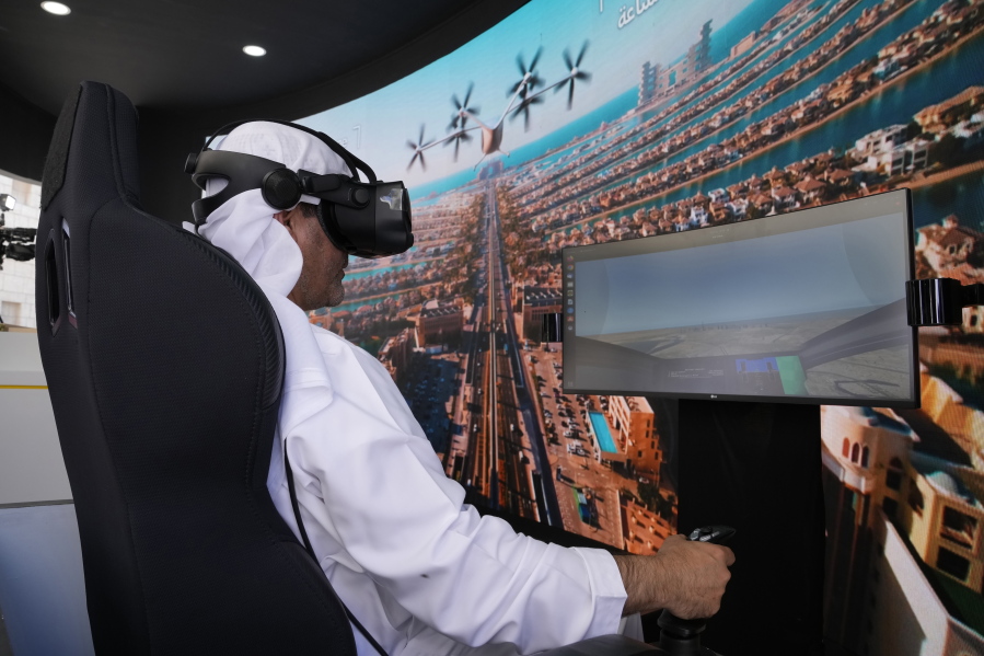 A man experiences a driving simulator of a flying taxi at the Dubai Roads and Transportation Authority's stand during the World Government SummitWLD in Dubai, United Arab Emirates, Monday, Feb 13, 2023. Dubai again is planning for the takeoff of flying taxis in this futuristic city-state on the Arabian Peninsula, offering its firmest details yet Monday for a pledged launch by 2026.