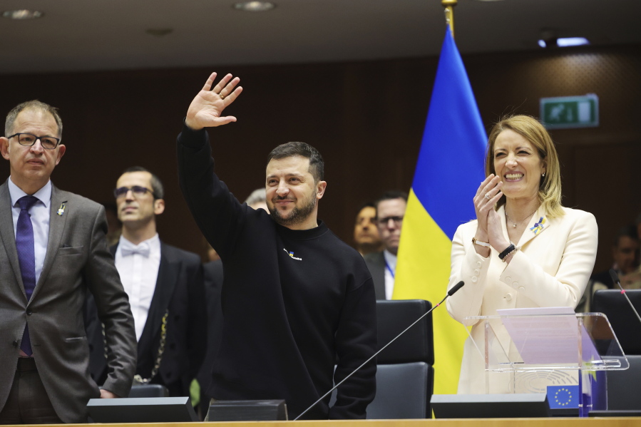 Ukraine's President Volodymyr Zelenskyy, centre, gestures as European Parliament's President Roberta Metsola, right, applauds during an EU summit at the European Parliament in Brussels, Belgium, Thursday, Feb. 9, 2023.